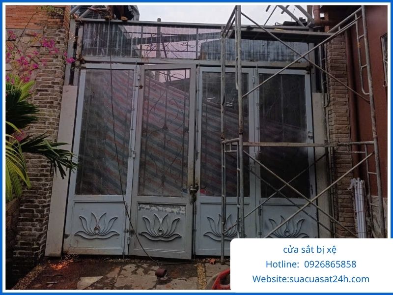 Cánh cửa cổng sắt cũ dầm mưa bị rỉ sét mục chân sập xệ nặng chuẩn bị dỡ bỏ thay mới