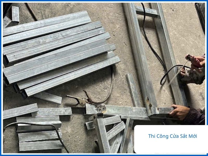 Các thanh sắt hộp mạ kẽm chống rỉ được chuẩn bị để thi công cửa sắt mới tại xưởng
