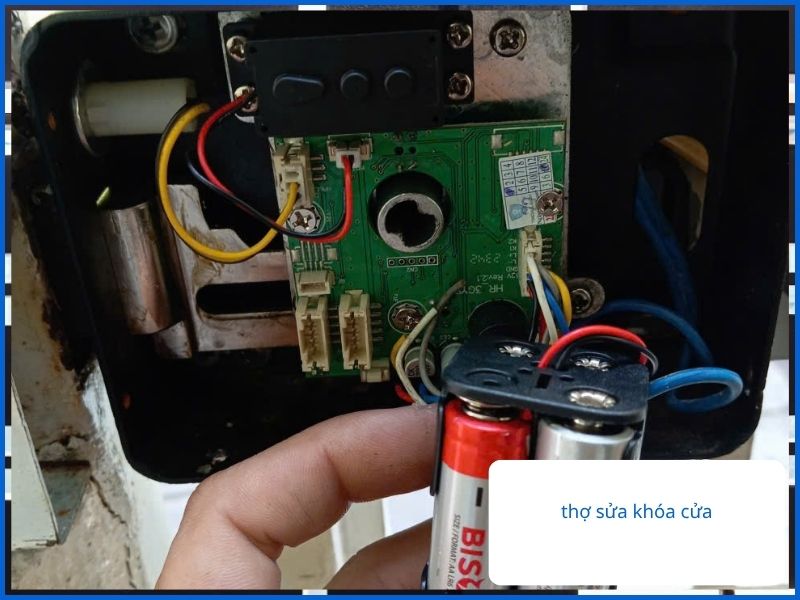 Thợ chuyên nghiệp đang kiểm tra bo mạch và thay pin cho khóa điện tử cửa sắt