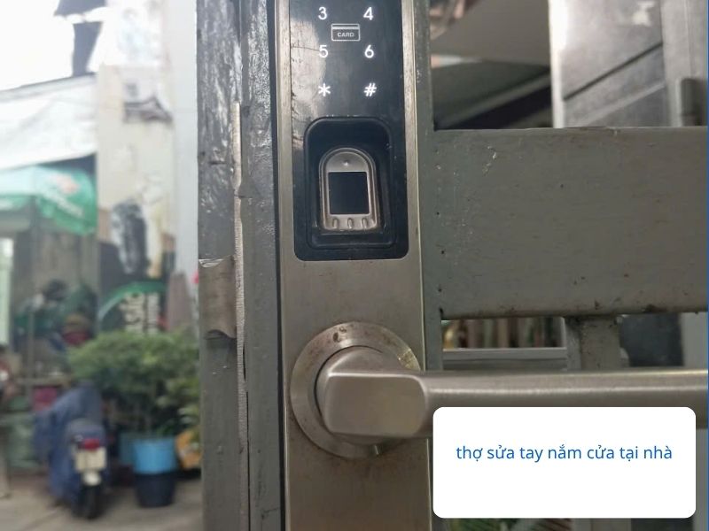Thợ khóa chuyên nghiệp đang kiểm tra và sửa cửa sắt bị kẹt khóa vân tay tay nắm tròn.