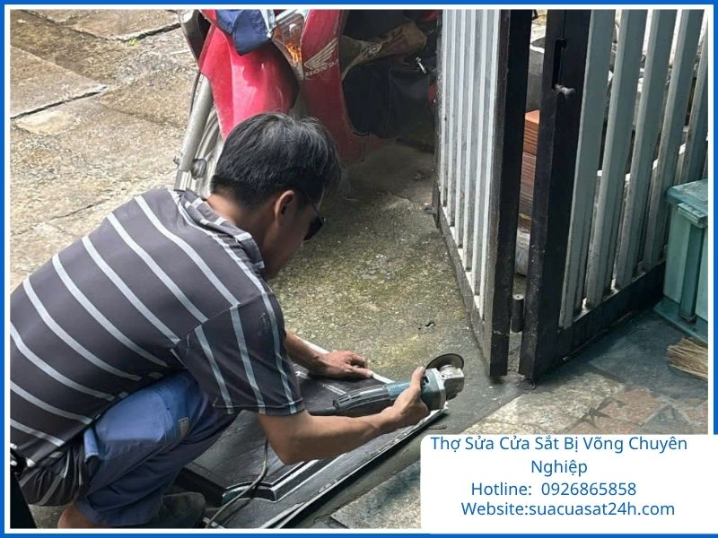 Thợ cơ khí chuyên nghiệp đang sửa cửa sắt bị võng