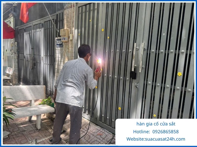 Thợ cơ khí đang hàn xì gia cố cửa sắt đứt gãy mối nối