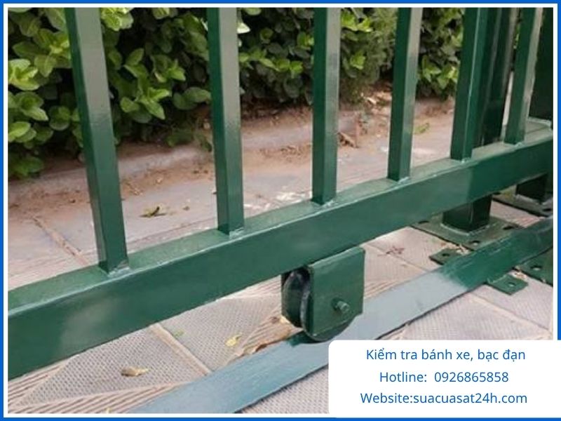 Thợ cơ khí kiểm tra và vệ sinh bánh xe bạc đạn cửa sắt lùa